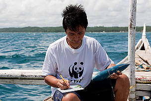WWF Philippines Donsol Research Coordinator Elson Aca writing down details of a Whale shark satellite tag into his slate. This is a SPLASH Tag deployed in 2007, it records position only for mapping whale sharks' movements. Donsol, Sorsogon, Bicol, Philippines. © Jürgen Freund / WWF WWF Philippines Donsol Research Coordinator Elson Aca writing down details of a Whale shark satellite tag into his slate. This is a SPLASH Tag deployed in 2007, it records position only for mapping whale sharks' movements. Donsol, Sorsogon, Bicol, Philippines.