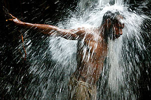 Tony, a villager from Pukapuki, stands under a waterfall that feeds into the April River, a tributary of the mighty Sepik River, in the province of East Sepik.